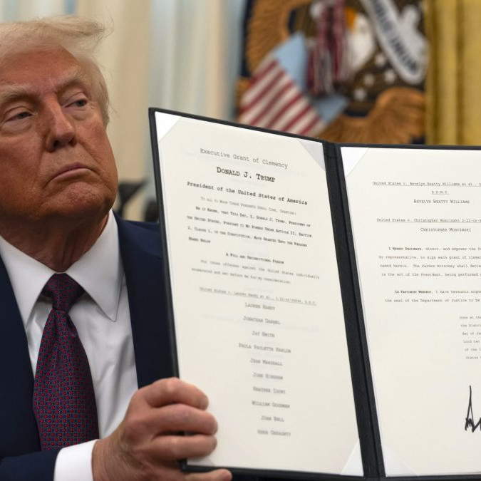 Na snímke je Donald Trump držiaci dekrét počas pózovania pre fotografov.