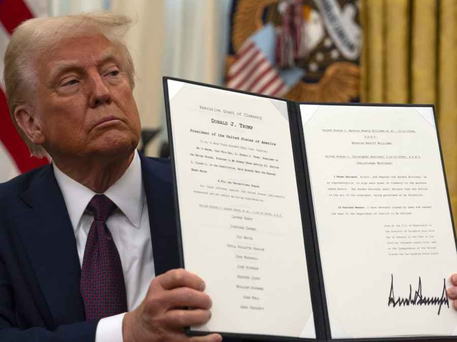 Na snímke je Donald Trump držiaci dekrét počas pózovania pre fotografov.