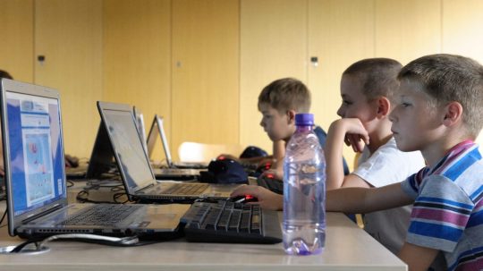 Ilustračná snímka detí pracujúcich s počítačmi.