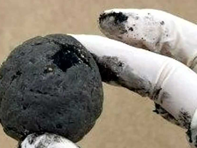 Na snímke osoba drží v ruke malú čiernu guľu.