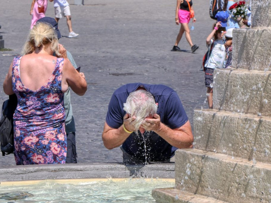 muž sa ovlažuje vo fontáne