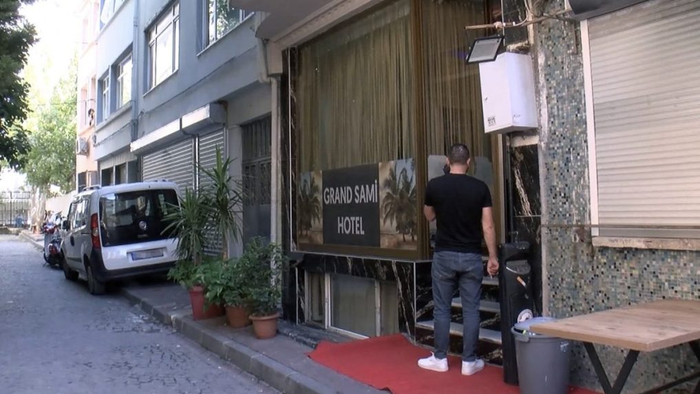 muž stojí pred vstupom do tureckého hotela