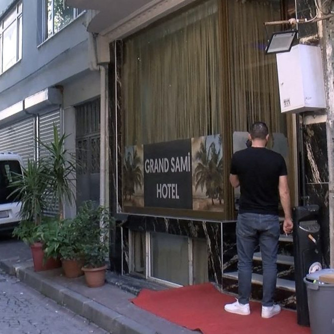 muž stojí pred vstupom do tureckého hotela