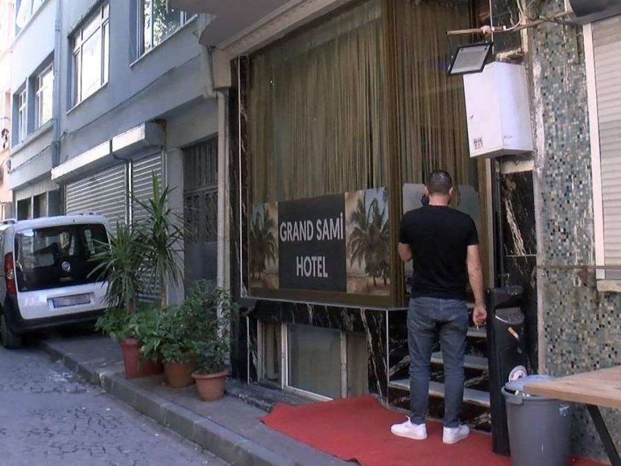 muž stojí pred vstupom do tureckého hotela