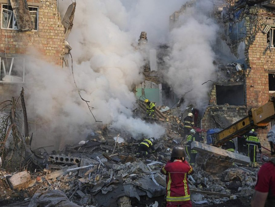 Na snímke hasiči zasahujú v obytnej budove, ktorú zasiahol útok ruskej armády.