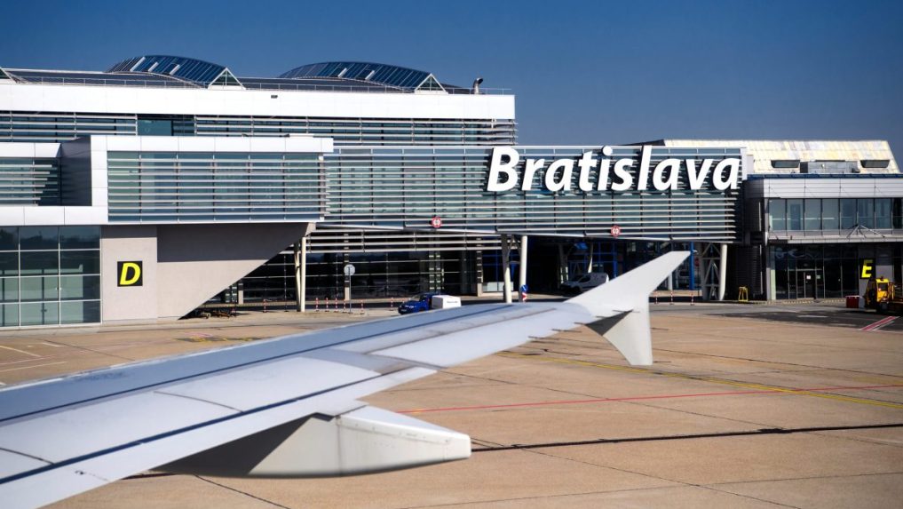 krídlo lietadla a budova bratislavského letiska