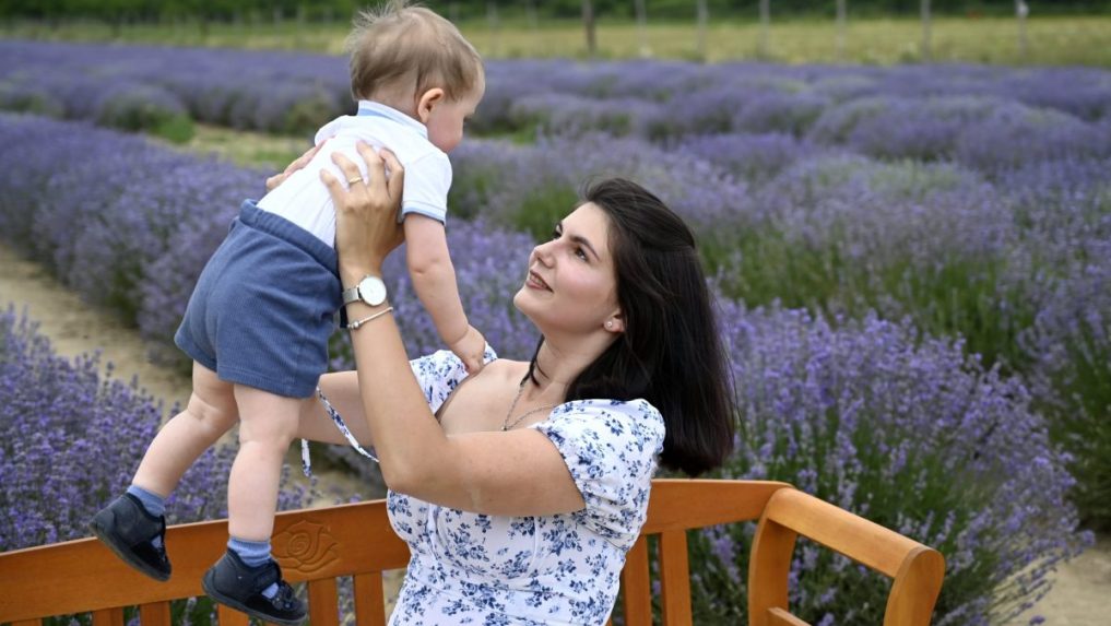 Na snímke matka s dieťaťom pózujú na levanduľovej farme.