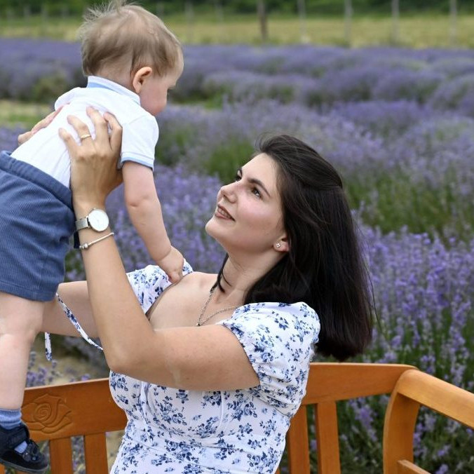 Na snímke matka s dieťaťom pózujú na levanduľovej farme.