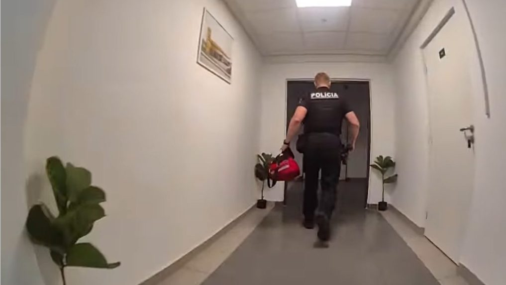 Na snímke policajt pri zásahu na žilinskej ubytovni.