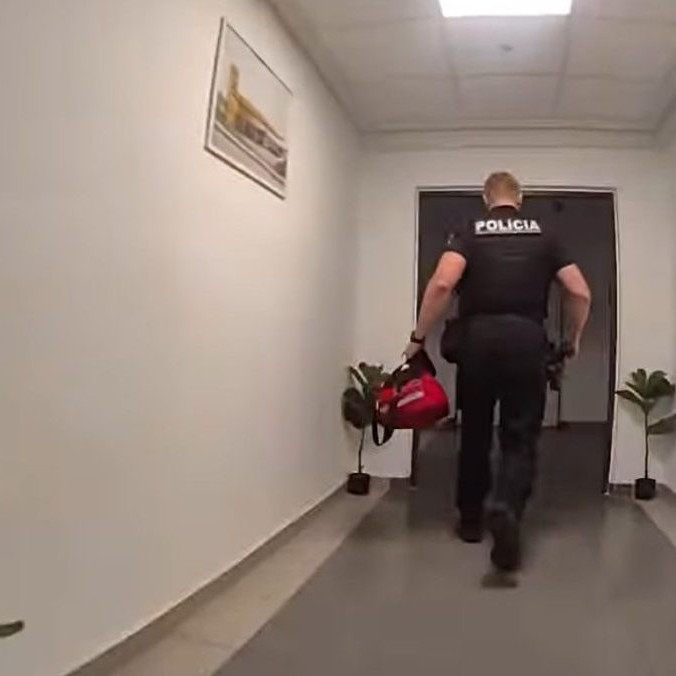 Na snímke policajt pri zásahu na žilinskej ubytovni.