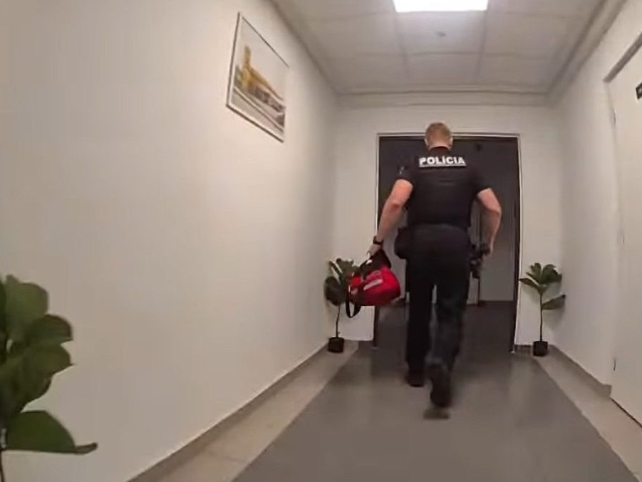 Na snímke policajt pri zásahu na žilinskej ubytovni.