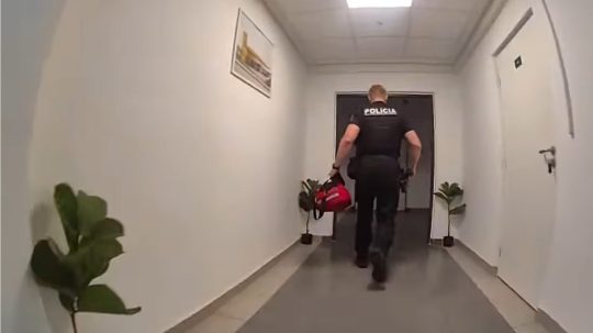 Na snímke policajt pri zásahu na žilinskej ubytovni.