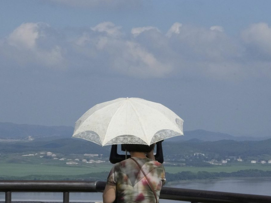 Osoba sleduje ďalekohľadom územie Severnej Kórey.