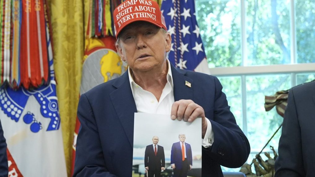 Donald Trump drží v rukách fotografiu seba a prezidenta Vladimira Putina zo samitu na Aljaške.