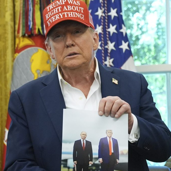 Donald Trump drží v rukách fotografiu seba a prezidenta Vladimira Putina zo samitu na Aljaške.