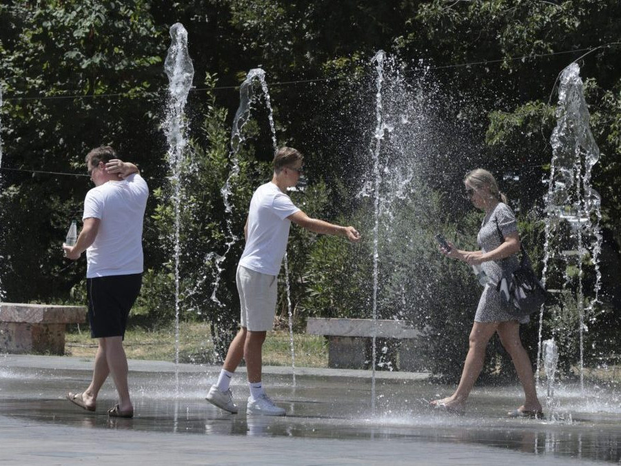 Ľudia sa ochladzujú v fontáne.