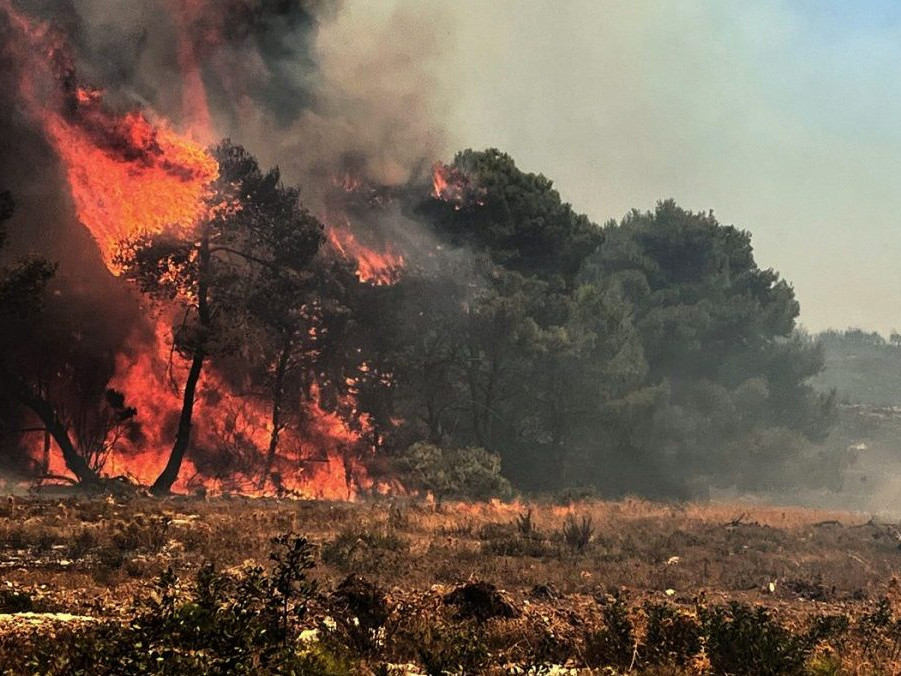 Na snímke mohutný požiar a hasič.