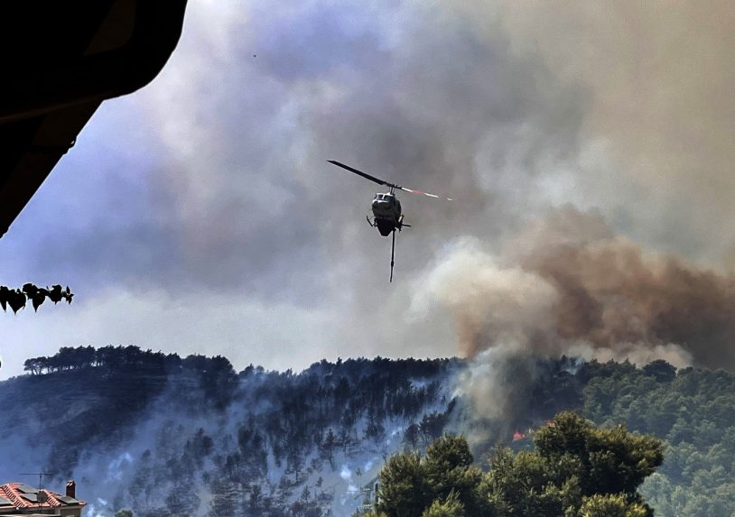 Na snímke vrtuľník nad horiacim ostrovom.