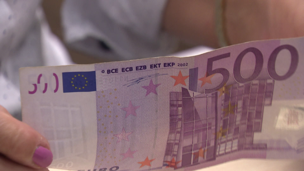 Na snímke je osoba, ktorá v rukách drží bankovku v hodnote 500 eur.