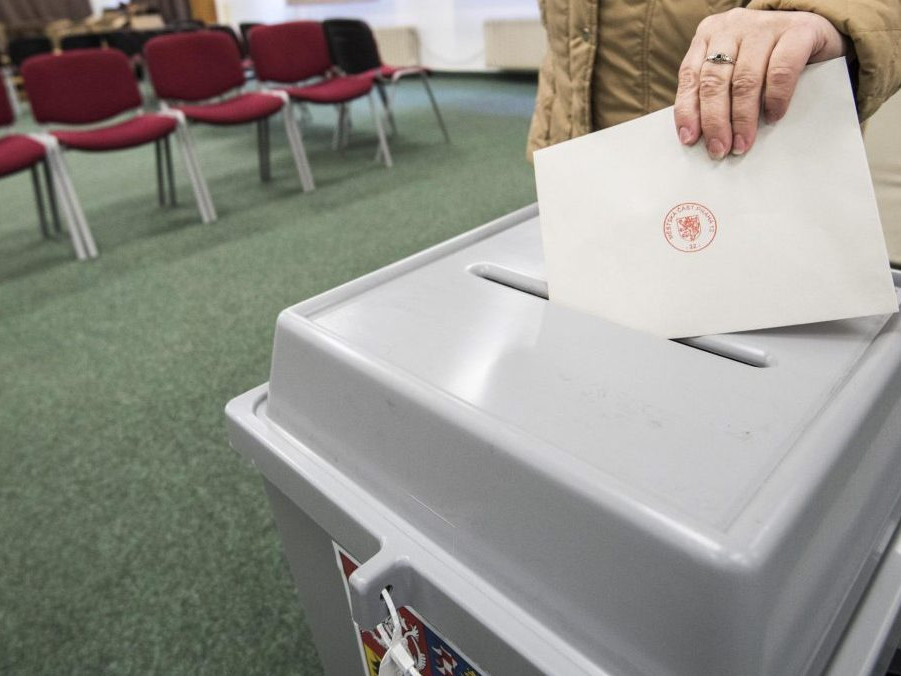 Volička vhadzuje svoj hlas do volebnej urny.