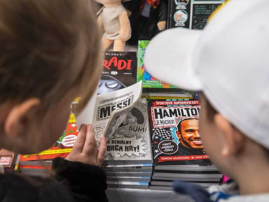 Na snímke si deti prezerajú knihu.