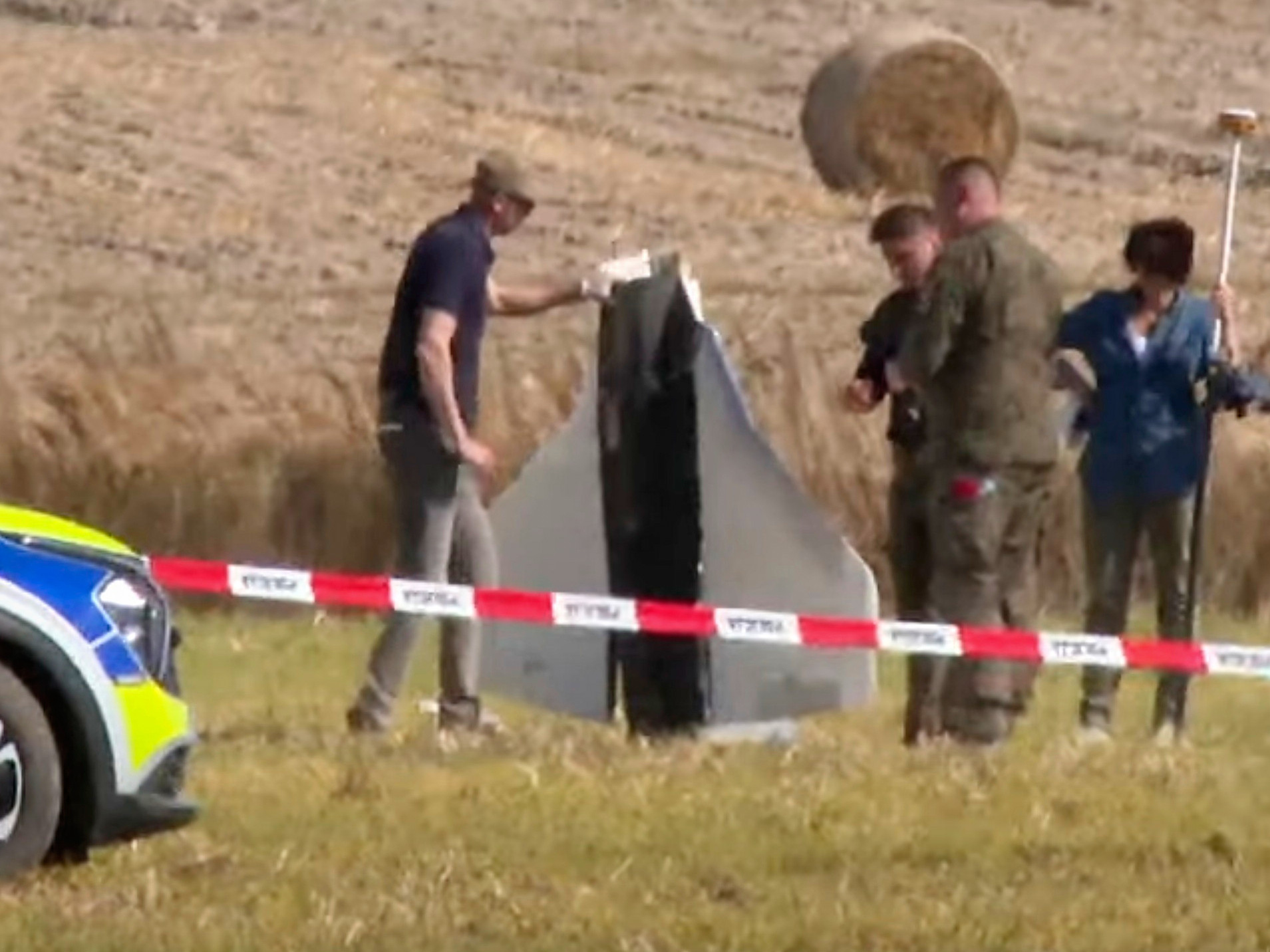 Príslušníci poľskej polície a armády zabezpečujú miesto, kde sa nachádzajú trosky ruského dronu.