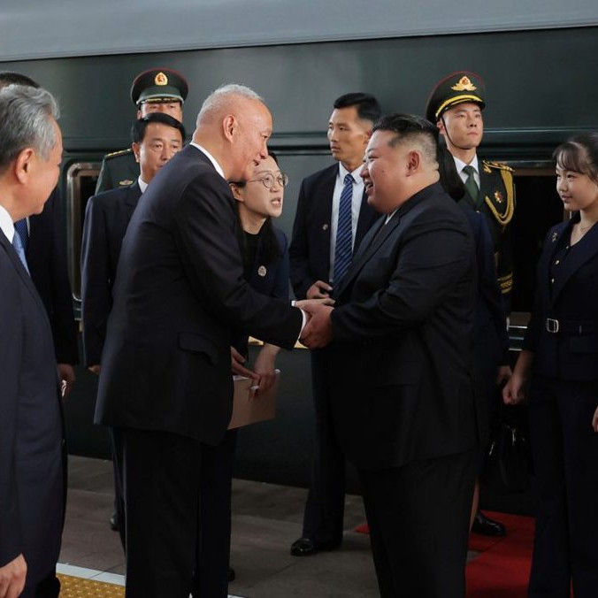 Zľava vrcholný čínsky politik Cchaj Čchi víta severokórejského vodcu Kim Čong-una (vpravo).