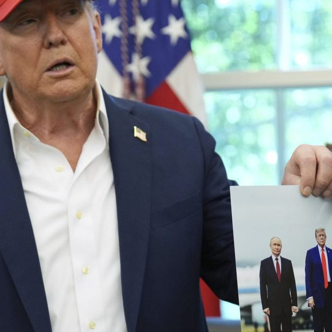 Na snímke Trump drží v ruke fotografiu zo stretnutia s Putinom.