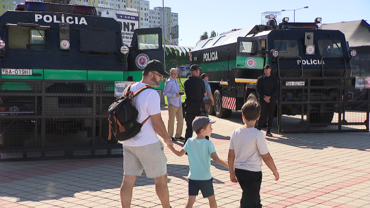 Snímka z Dňa ministerstva vnútra, na snímke veľké policajné stroje, v popredí muž s dvomi deťmi.