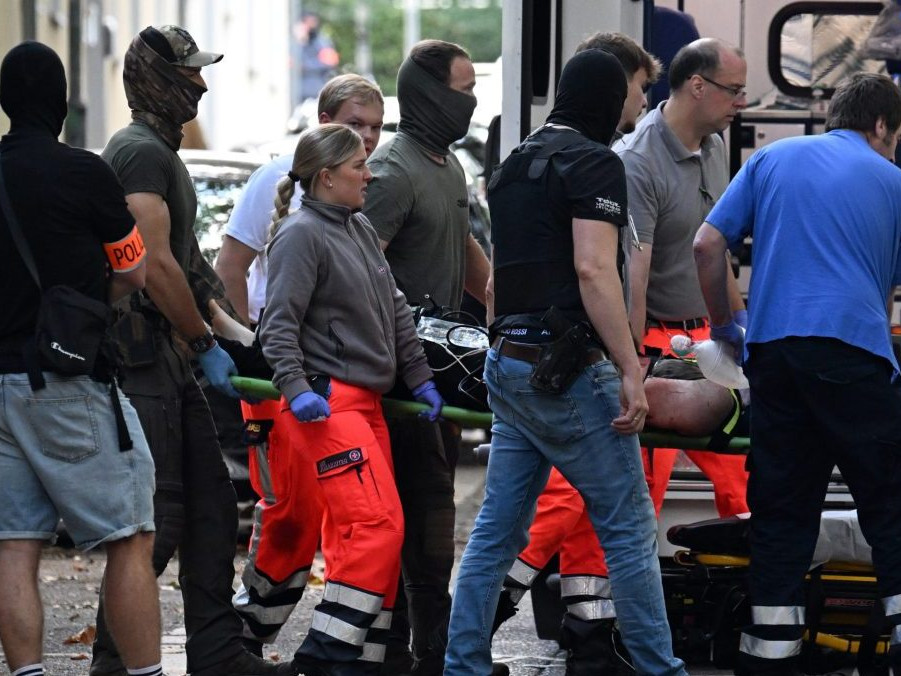 Na snímke zdravotníci odvážajú na nosidlách páchateľa.