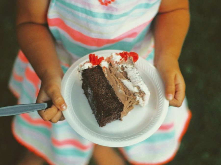 Dieťa so zákuskom na tanieri.