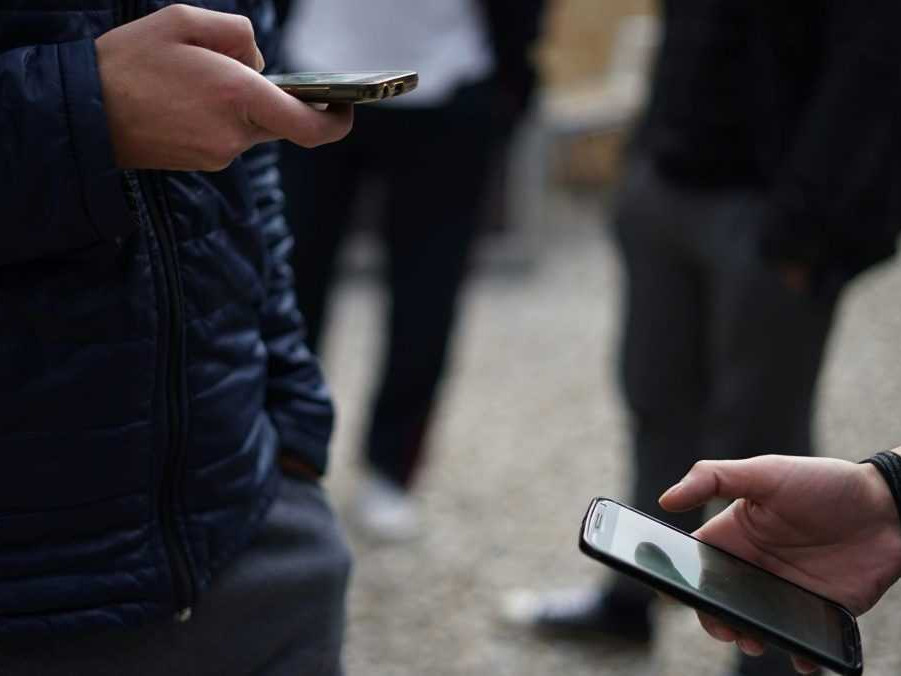 Ilustračná snímka mládeže s mobilnými telefónmi.