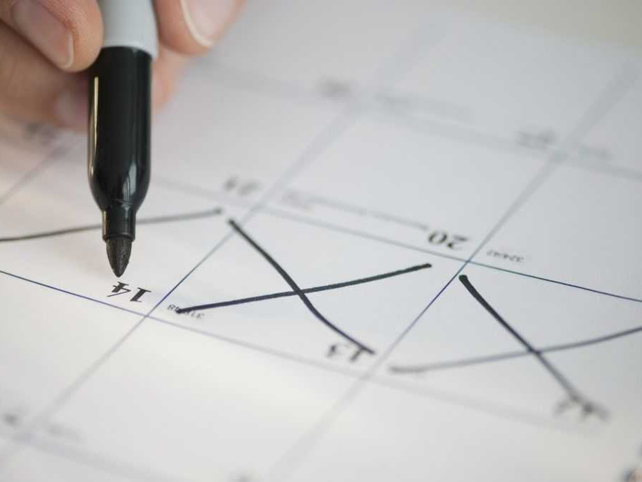 Na snímke kalendár, osoba v ňom krížikom vyznačuje dni.