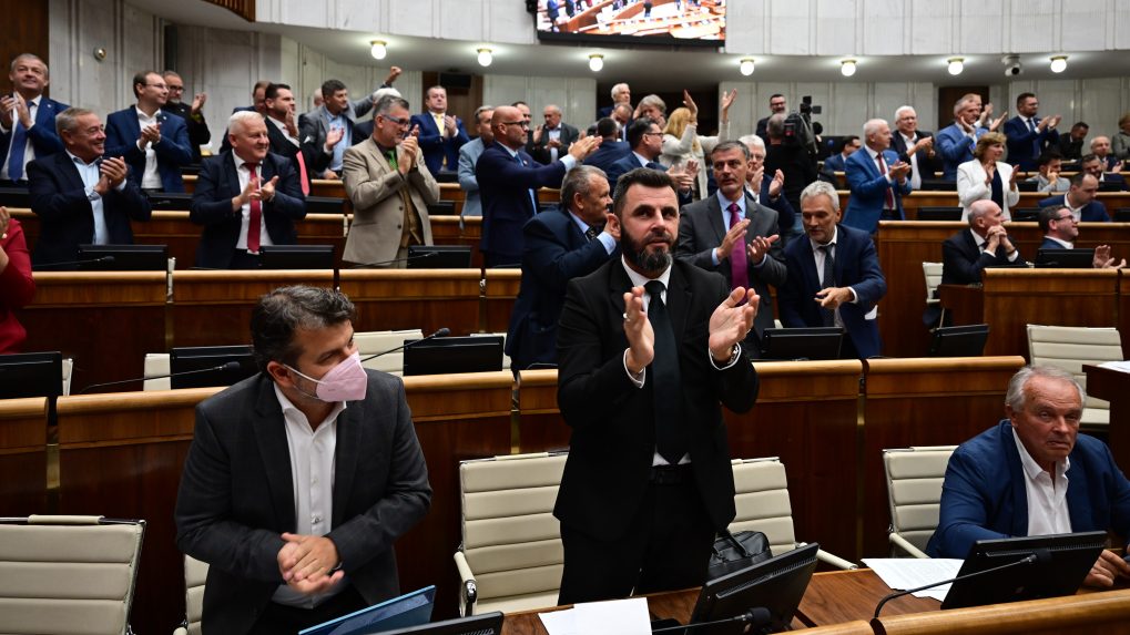 Koaliční poslanci a v pozadí vpravo poslanci KDH tlieskajú po schválení novely ústavy.