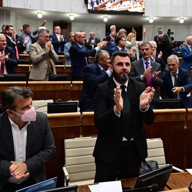 Koaliční poslanci a v pozadí vpravo poslanci KDH tlieskajú po schválení novely ústavy.