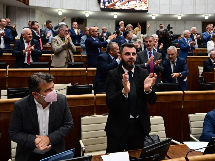 Koaliční poslanci a v pozadí vpravo poslanci KDH tlieskajú po schválení novely ústavy.