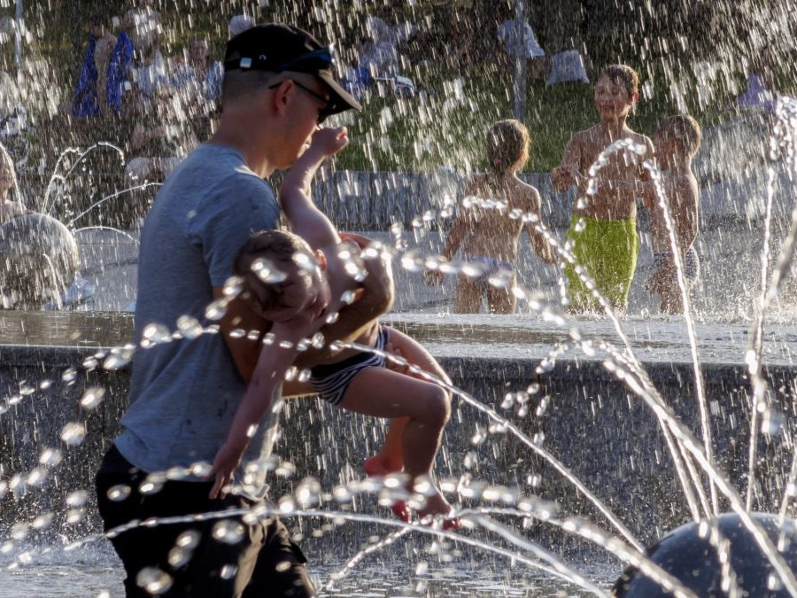 Na snímke deti si užívajú letný prázdninový podvečer vo fontáne Družba na Námestí slobody v Bratislave.
