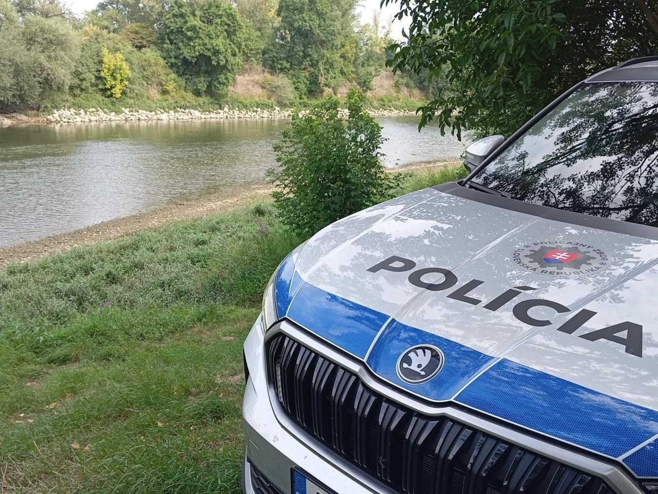 Na ilustračnej snímke policajné auto pri rieke Váh.