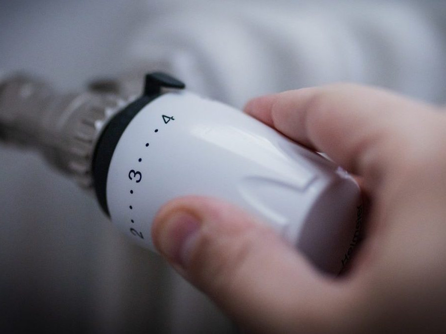 Ruka na termostatickej hlavici radiátora.