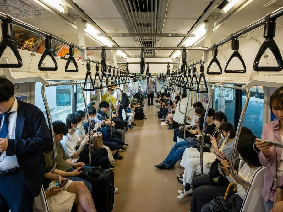 Ilustračná snímka ľudí na mobilných telefónoch počas cesty hromadnou dopravou.