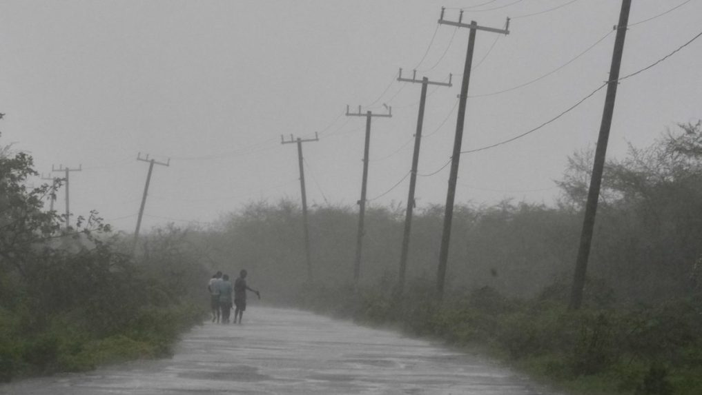 Ľudia kráčajú po ceste počas príchodu hurikánu Melissa v Rocky Point.
