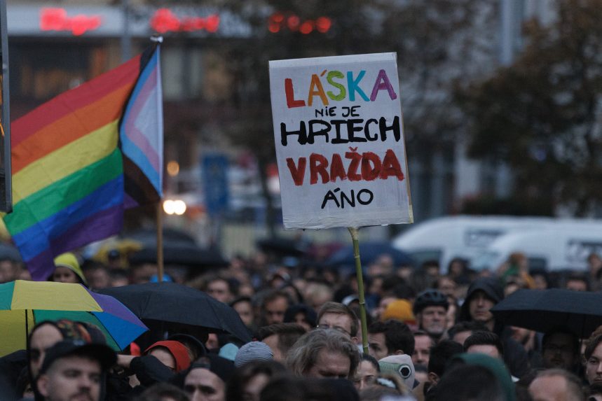 Účastník s transparentmi na Námestí SNP v Bratislave počas spomienkového zhromaždenia za dve obete úkladnej vraždy zo stredy 12. októbra 2022 večer pred LGBTI podnikom Tepláreň a pochodu za odsúdenie nenávisti voči LGBTI komunite, ktorý v Bratislave organizovala Iniciatíva Inakosť.
