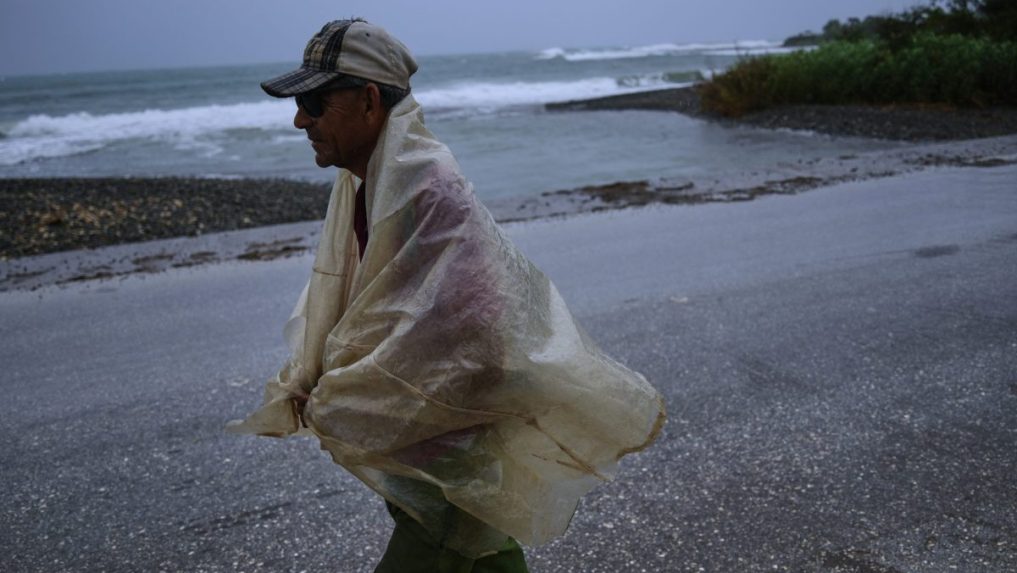 Muž kráča v daždi pred príchodom hurikánu Melissa v Canizo.