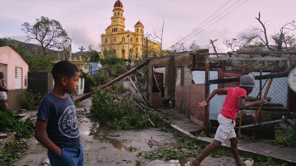 Chlapci kráčajú v El Cobre na Kube po prechode hurikánu Melissa.