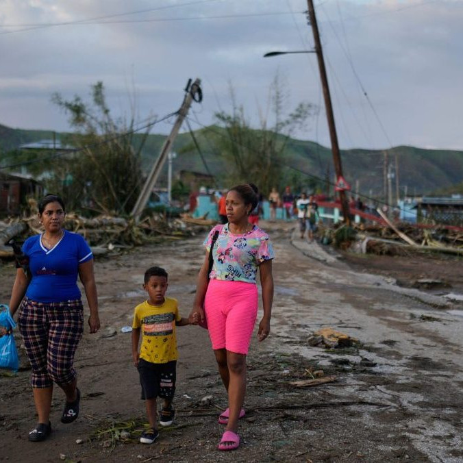 Obyvatelia kráčajú po hurikáne Melissa v kubánskom meste El Cobre.