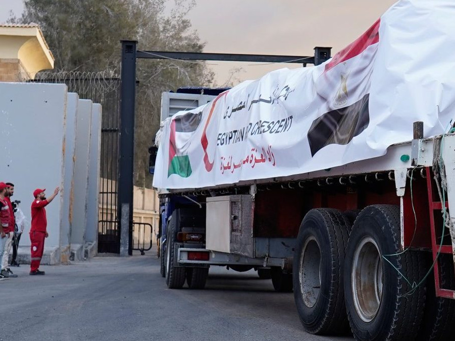 Príslušníci Egyptského Červeného kríža monitorujú kamióny vezúce humanitárnu pomoc.