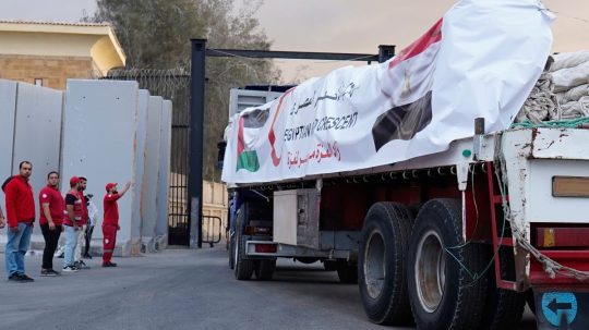 Príslušníci Egyptského Červeného kríža monitorujú kamióny vezúce humanitárnu pomoc.