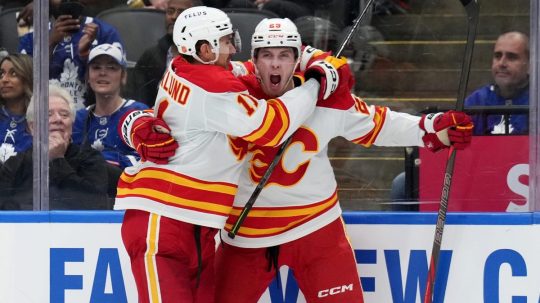 Slovenský útočník Samuel Honzek z Calgary Flames sa teší z gólu s Mikaelom Backlundom.