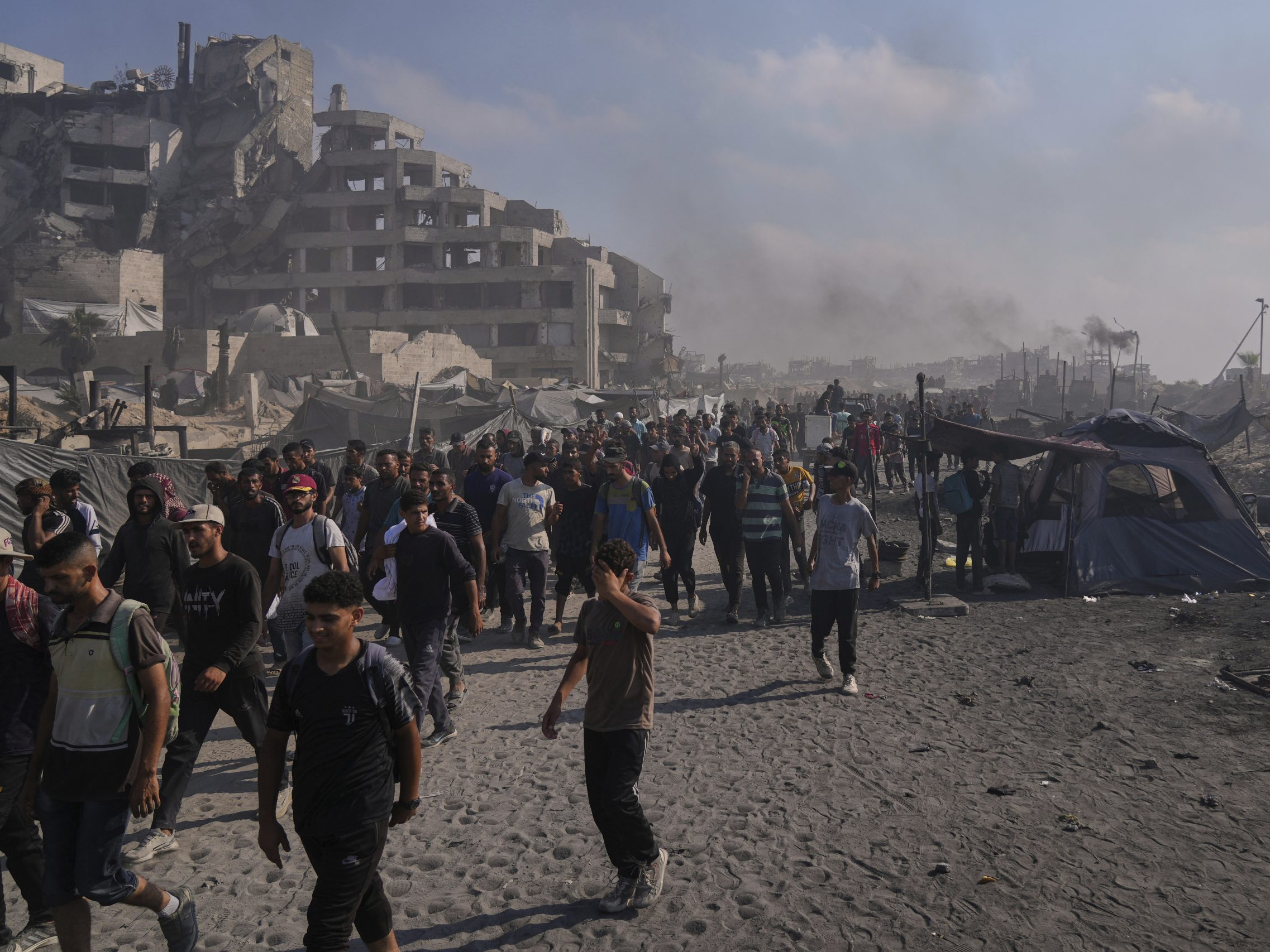 Palestínčania kráčajú po ceste smerom k oblasti na severe Pásma Gazy, kam vchádzajú nákladné autá s humanitárnou pomocou v meste Gaza.