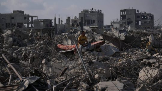 Palestínčan sedí v troskách svojho trojposchodového domu.